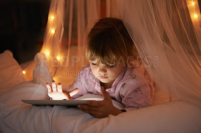 Buy stock photo Little girl, bed and tablet at night, browsing and watching with technology for streaming or learning. Child, tech and internet for online games or digital reading with touch and internet in bedroom
