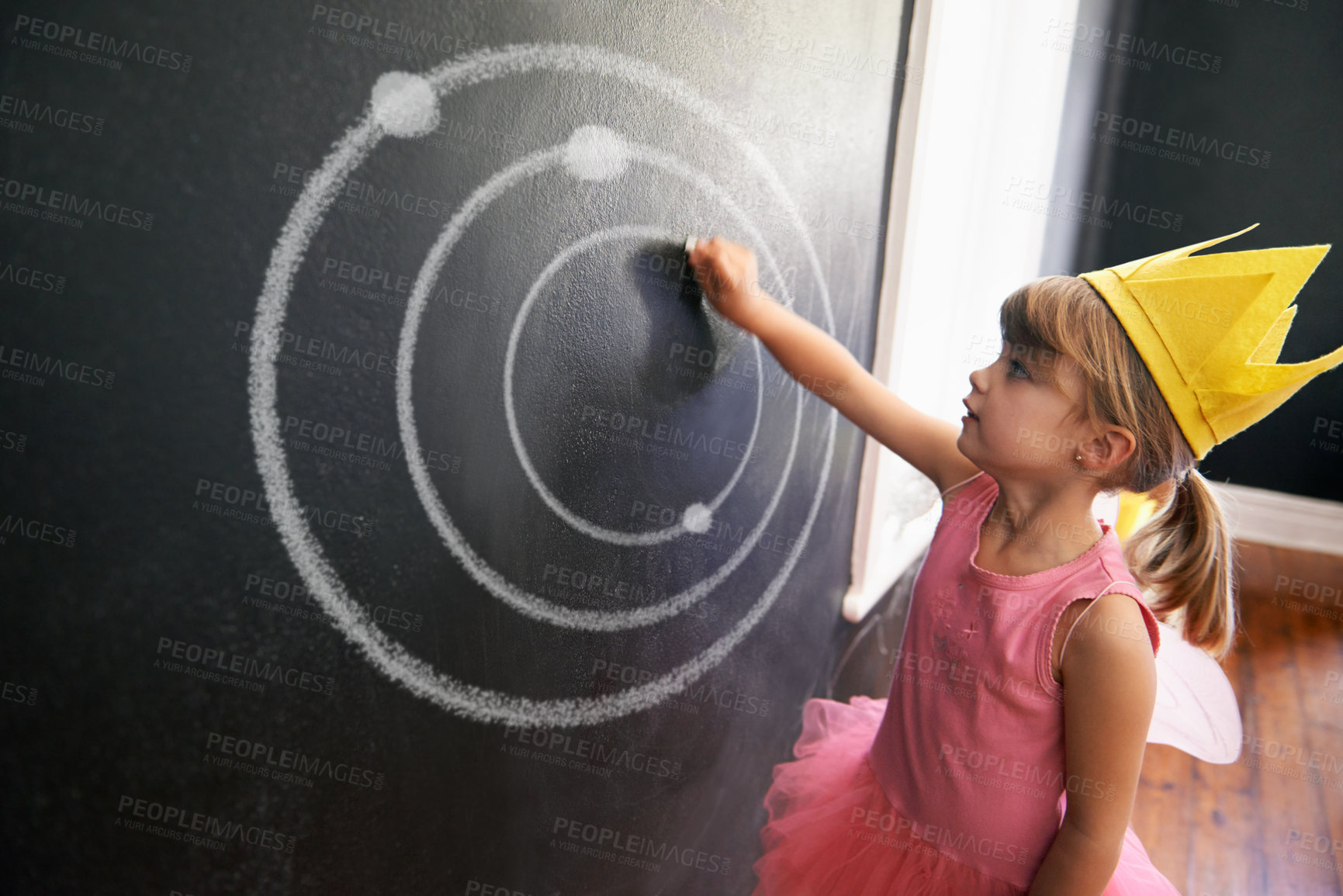 Buy stock photo Child, board and drawing solar system for education with chalk in classroom with costume for creative, learning and guidance. Kid, chalkboard and crown for picture student in school for knowledge