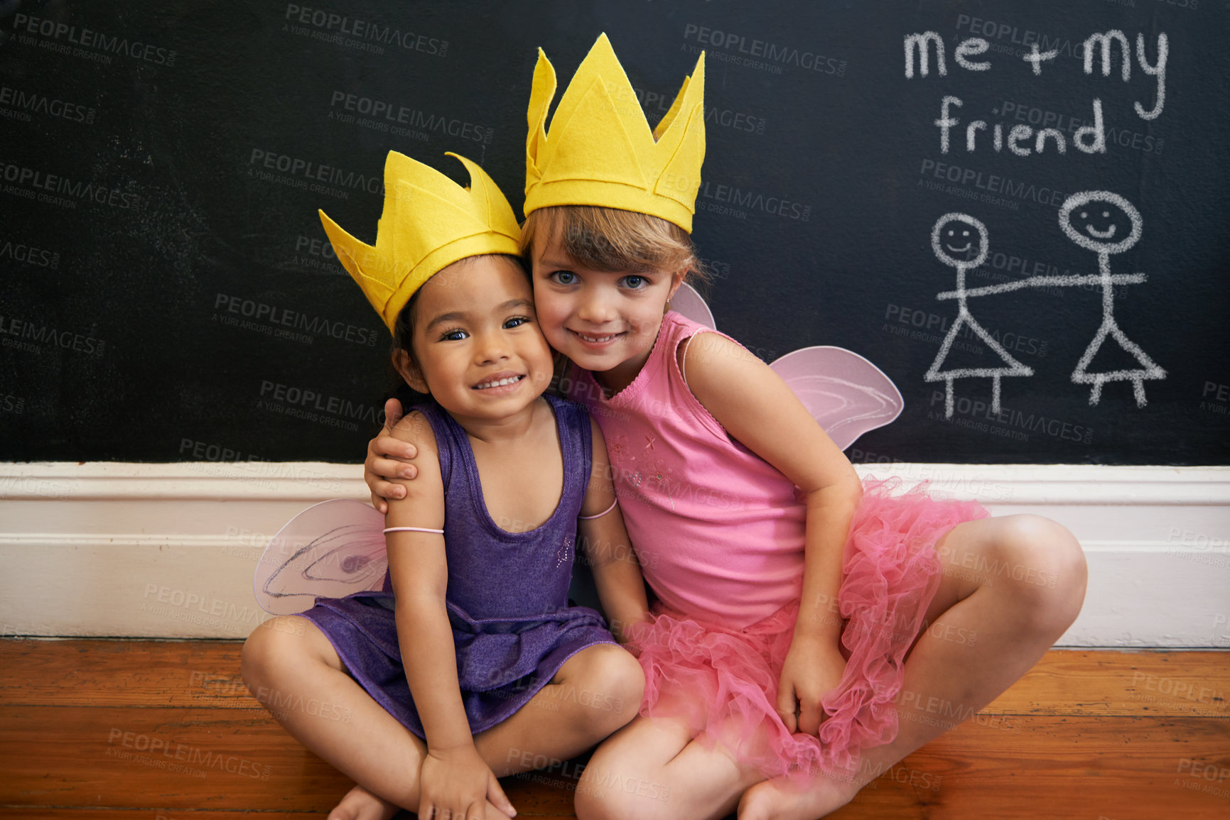 Buy stock photo Little girls, friends and portrait with embrace, crown and smile for love and happiness. Children, youth and hug for face, fun and bonding with blackboard and fairy princess costume for dress up
