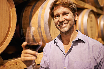Buy stock photo Portrait, wine and taste with a man in the cellar of a distillery on a farm for production or fermentation of alcohol. Glass, winery and barrel with a male farmer tasting a drink for quality control