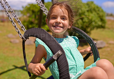 Buy stock photo Cheerful child, swing and playing at a playground with summer hobby for kids or kindergarten leisure activity. Portrait, little girl and outdoor in nature park for fun and happiness with a smile