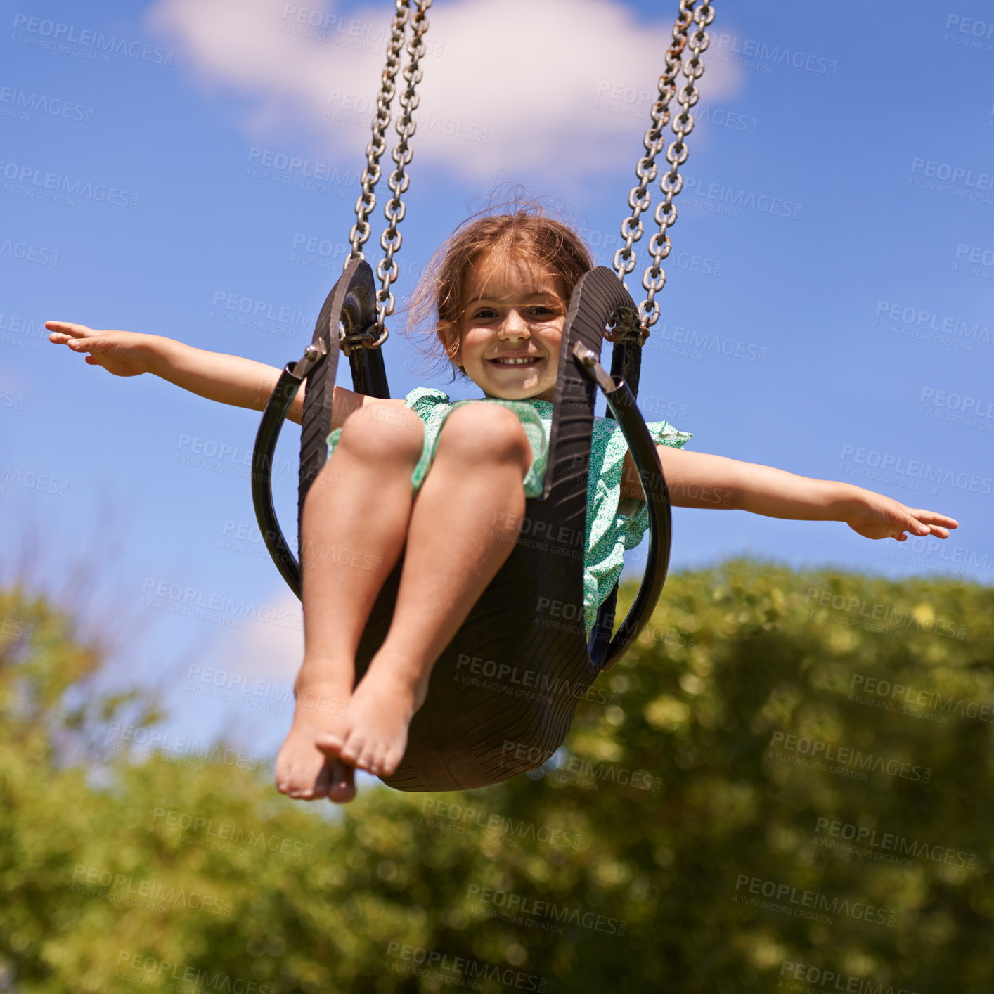 Buy stock photo Shot of a young girl playing on a swing outsdie