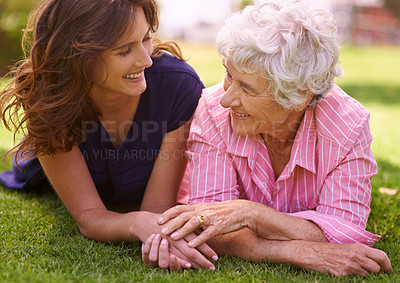 Buy stock photo Senior, mother and happy outdoor with woman to relax on grass in summer, holiday or vacation together. Elderly, mom and family holding hands with love and support and smile in retirement in garden