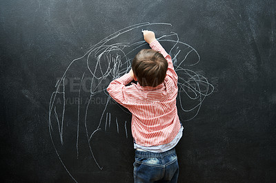 Buy stock photo A young boy drawing on a blackboard
