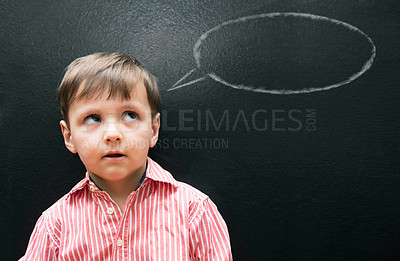 Buy stock photo Child, boy and thinking with speech bubble on blackboard for creative idea, drawing and illustration in classroom. Student, kid and face with daydreaming, contemplating and question with chalkboard