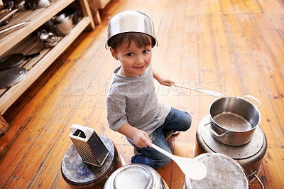 Buy stock photo Portrait, fun and boy child playing drums on pans on a floor, happy and enjoying music. Face, creative and kid with pots for musical entertainment, silly and carefree in a kitchen on the weekend