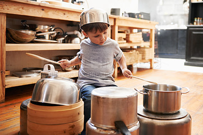 Buy stock photo A young boy playing drums on pots and pans