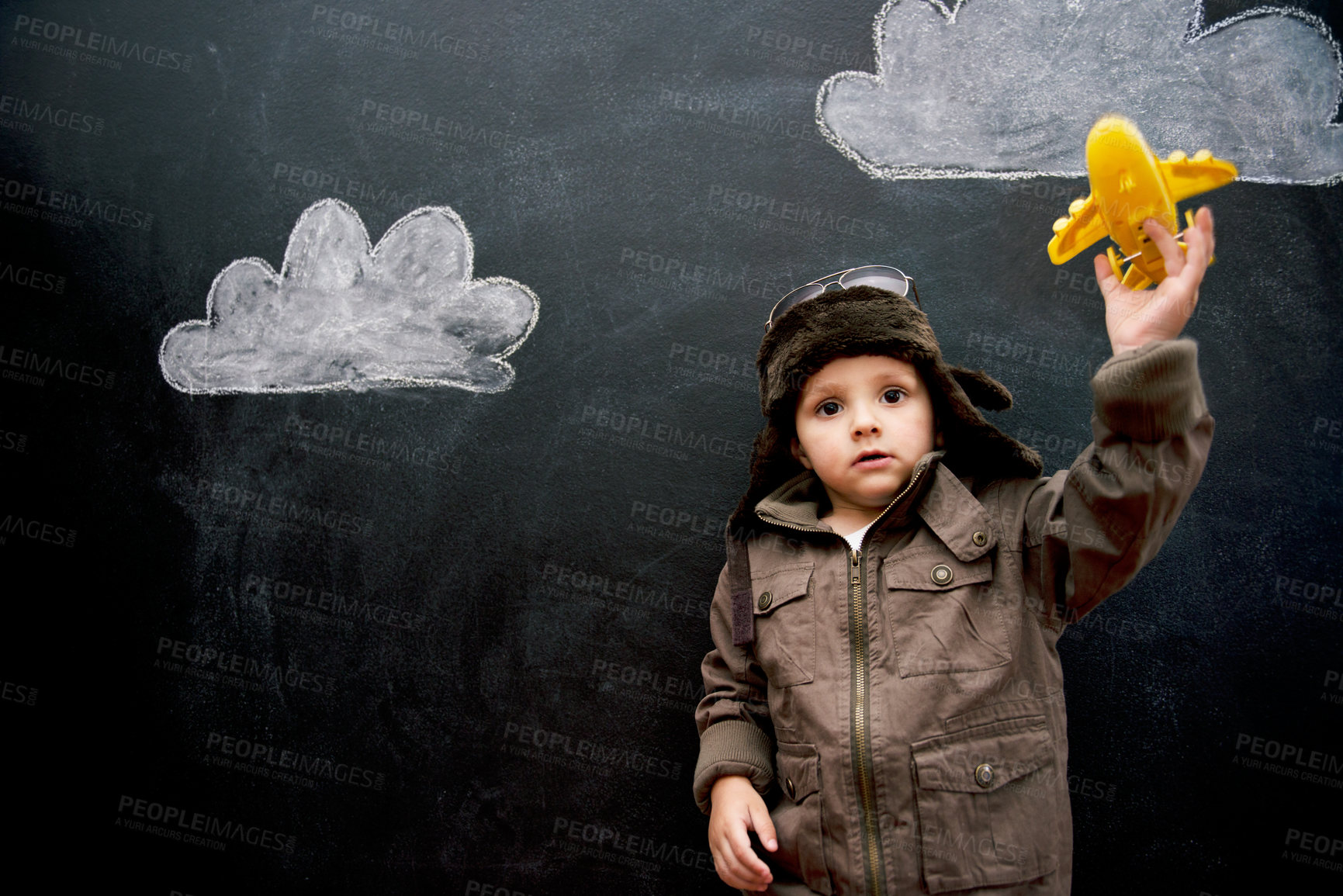 Buy stock photo Child, boy and face by blackboard with plane for creative fun, playing or drawing of clouds for imagination. Student, kid and confidence with airplane, chalkboard or illustration for knowledge or sky