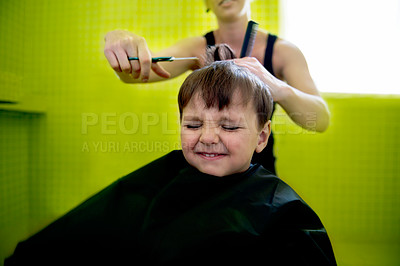 Buy stock photo Kid, boy and hairdresser with haircut at salon for grooming, hairstyle and grimace with scissors. Barber, person and child for hair treatment, haircare and hairdressing with comb, happy and grimace