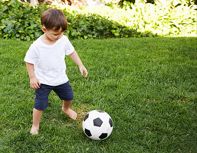 Buy stock photo A sweet little boy with a soccer ball in the backyard