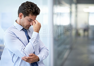 Buy stock photo A young businessman looking stressed-out at the office