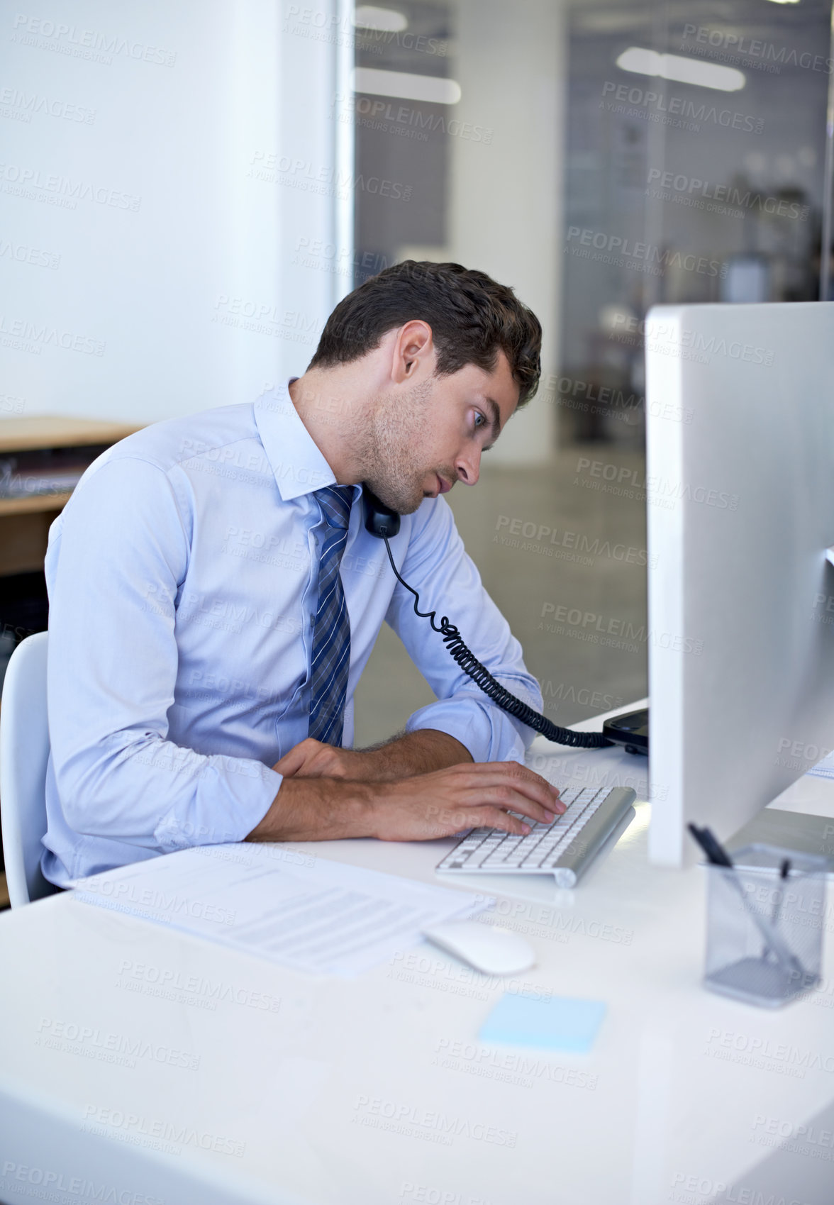 Buy stock photo Businessman, phone call and computer in office or client communication or online sales, internet or networking. Male person, telephone and typing in New York company or job, discussion or connection