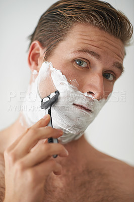 Buy stock photo A handsome young man shaving