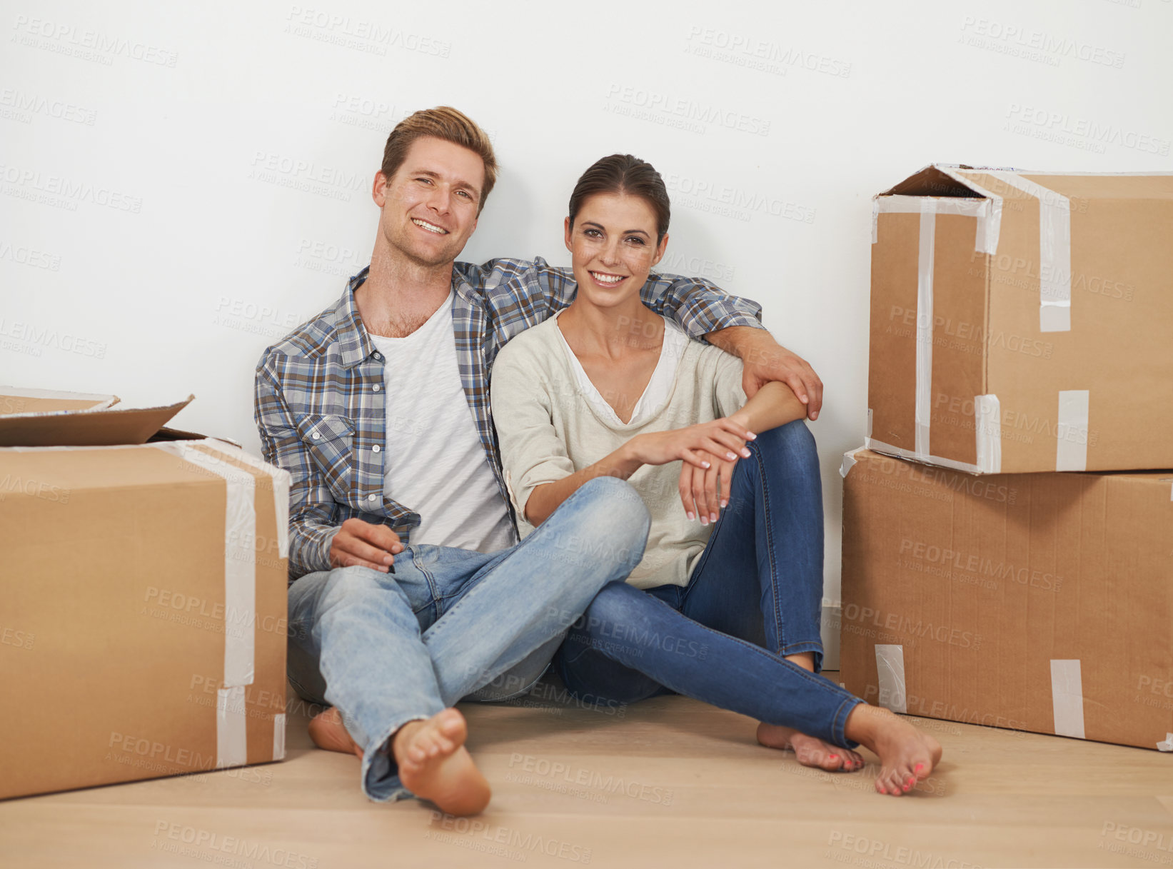 Buy stock photo New home, portrait and happy couple with boxes in living room, moving and relax for investment in real estate. Man, woman and proud homeowners with package in property and mortgage loan for apartment