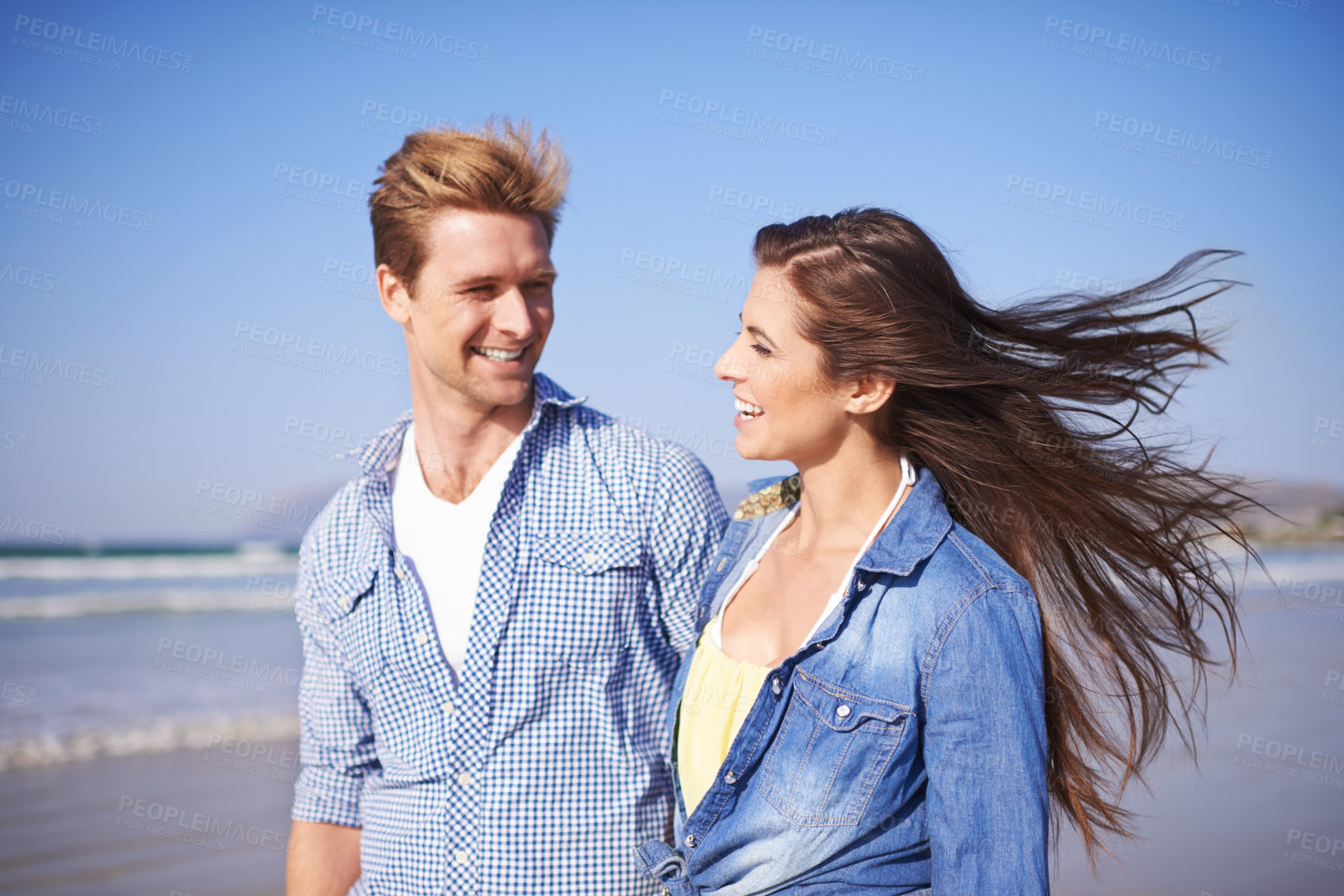 Buy stock photo Couple, smile and walk on beach for romantic date on sunny afternoon with blue sky in New Zealand. Happy, man and woman in love for sweet relationship, fun dating and bonding together in summer