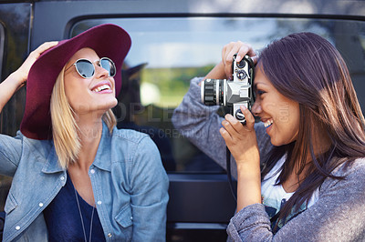 Buy stock photo Shot of a two girlfriends taking photos of themselves while on a roadtrip