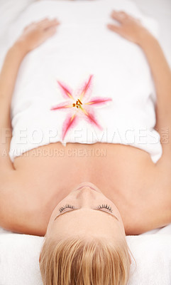 Buy stock photo Relax, massage and woman at spa with flower for luxury holistic treatment, facial health and sleep in towel. Self care, peace and refresh for girl on bed in natural rest for body wellness from above