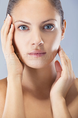 Buy stock photo Natural, beauty and hands on face of woman in studio for dermatology, shine or glow on blue background. Skin, portrait and female model with soft, results or cosmetic wellness, treatment or routine