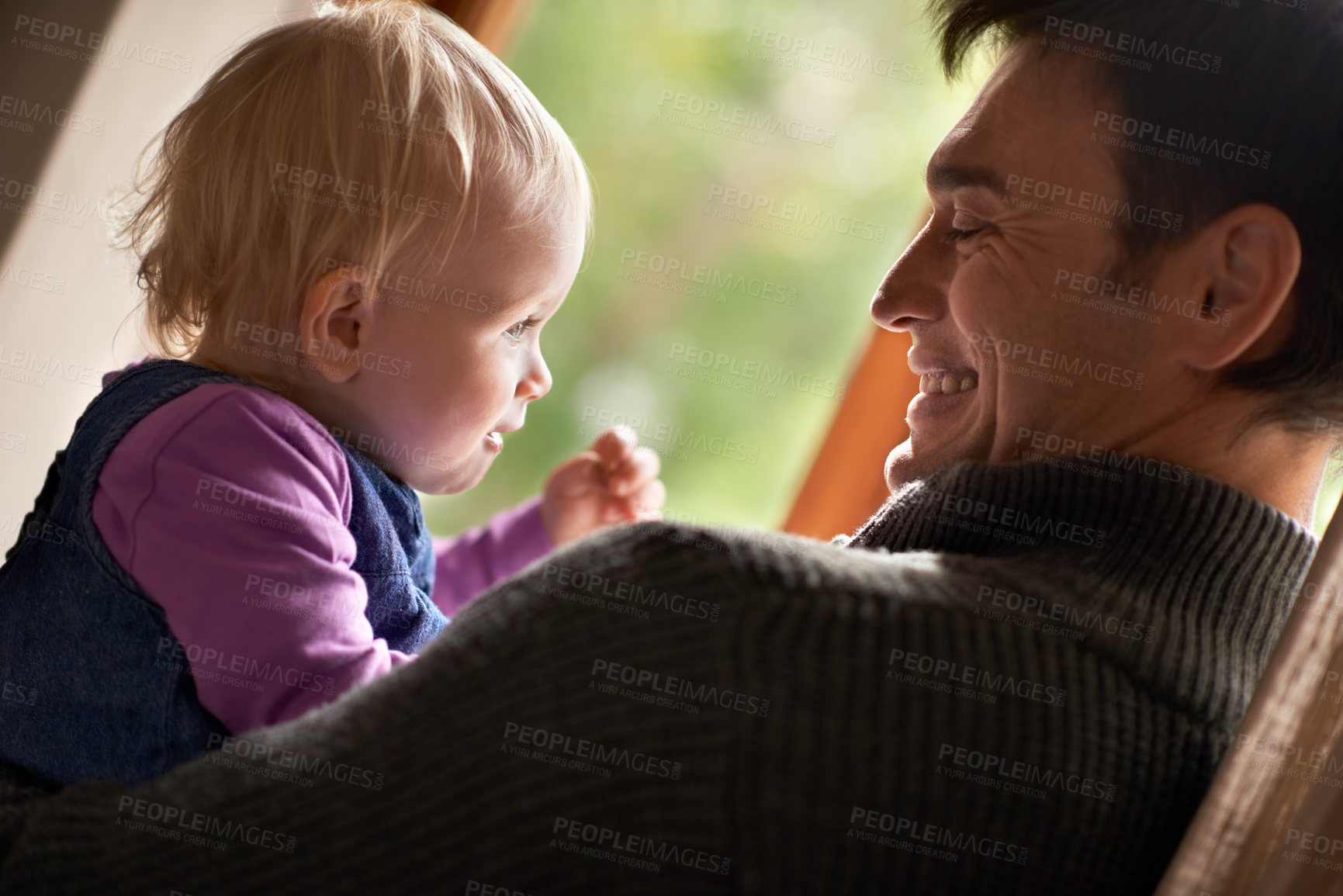 Buy stock photo A young father holding his baby girl in his arms