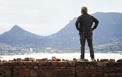 Buy stock photo Man, watching mountains and thinking of adventure ideas and inspiration in Cape Town, South Africa. Male person and natural scenery for contemplating, planning and explore on wall with mock up