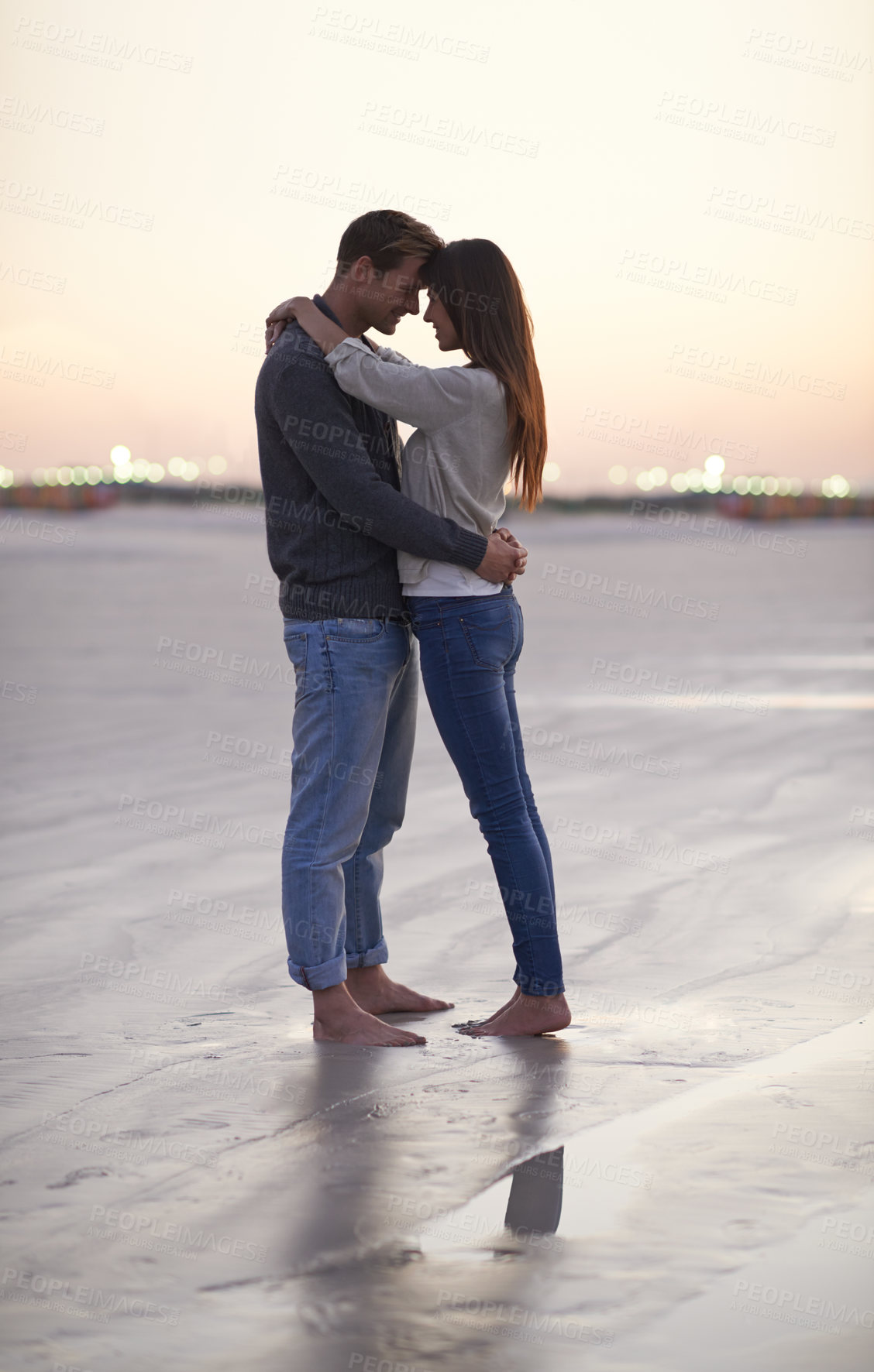 Buy stock photo A young couple enjoying a romantic moment together at the beach