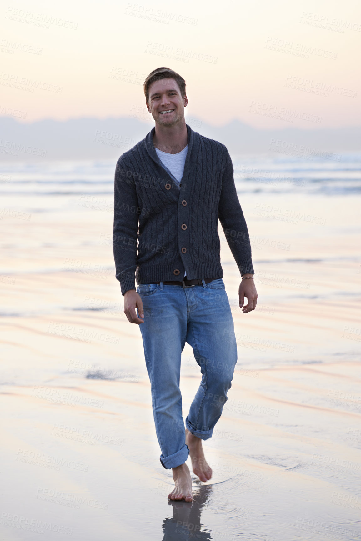 Buy stock photo Man, walking and happy in portrait by ocean, sunset and vacation with nature to relax at beach. Person, travel and outdoor by sea with feet in sand for holiday, adventure or smile by sea in Australia