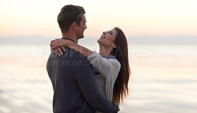 Buy stock photo Love, hug and happy couple at ocean at sunset for tropical holiday adventure, relax and bonding together. Laughing, man and woman on romantic date with beach, evening sky and embrace on vacation.