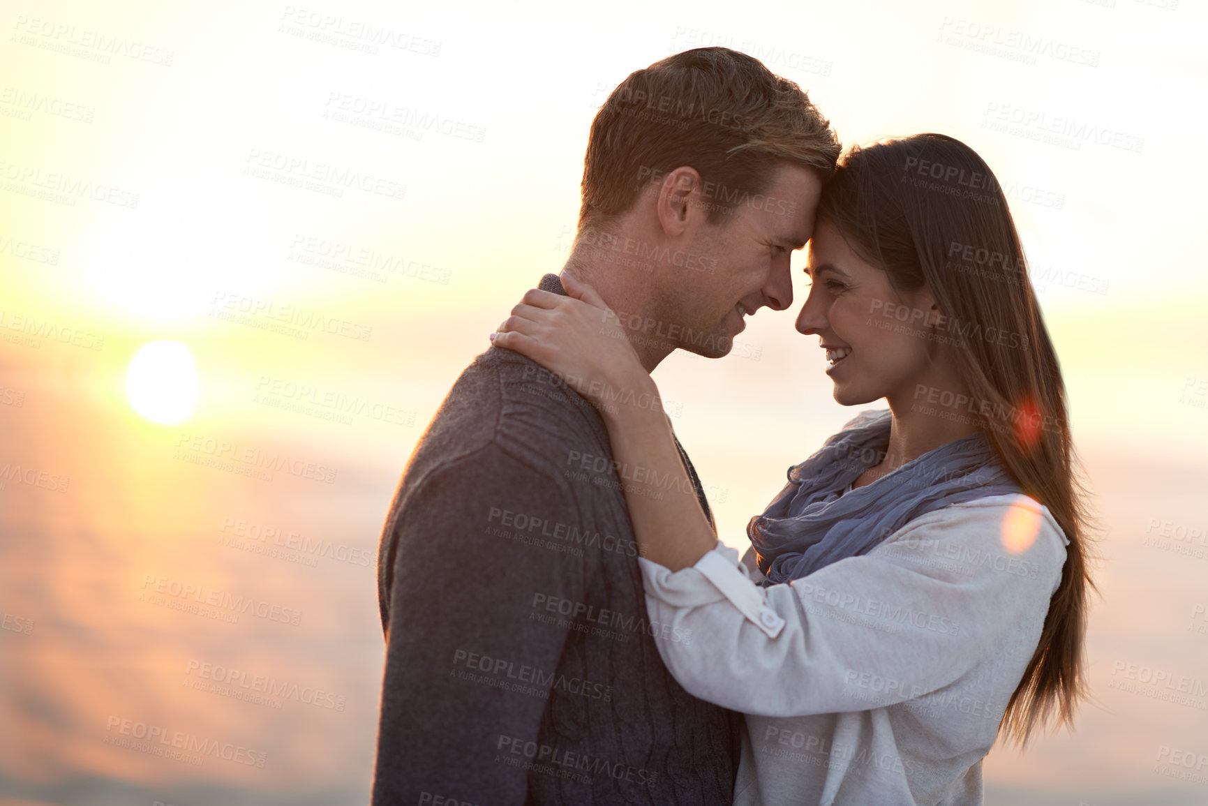 Buy stock photo A young couple enjoying a romantic moment together at the beach