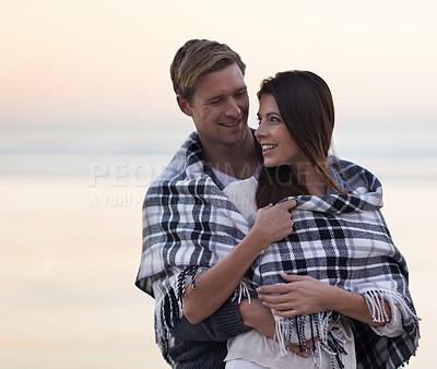 Buy stock photo Couple, hug and sunset at beach with blanket for vacation, love and care in nature, outdoor and ocean. Man, woman and embrace with smile, bonding and happy for memory on holiday by sea in Australia