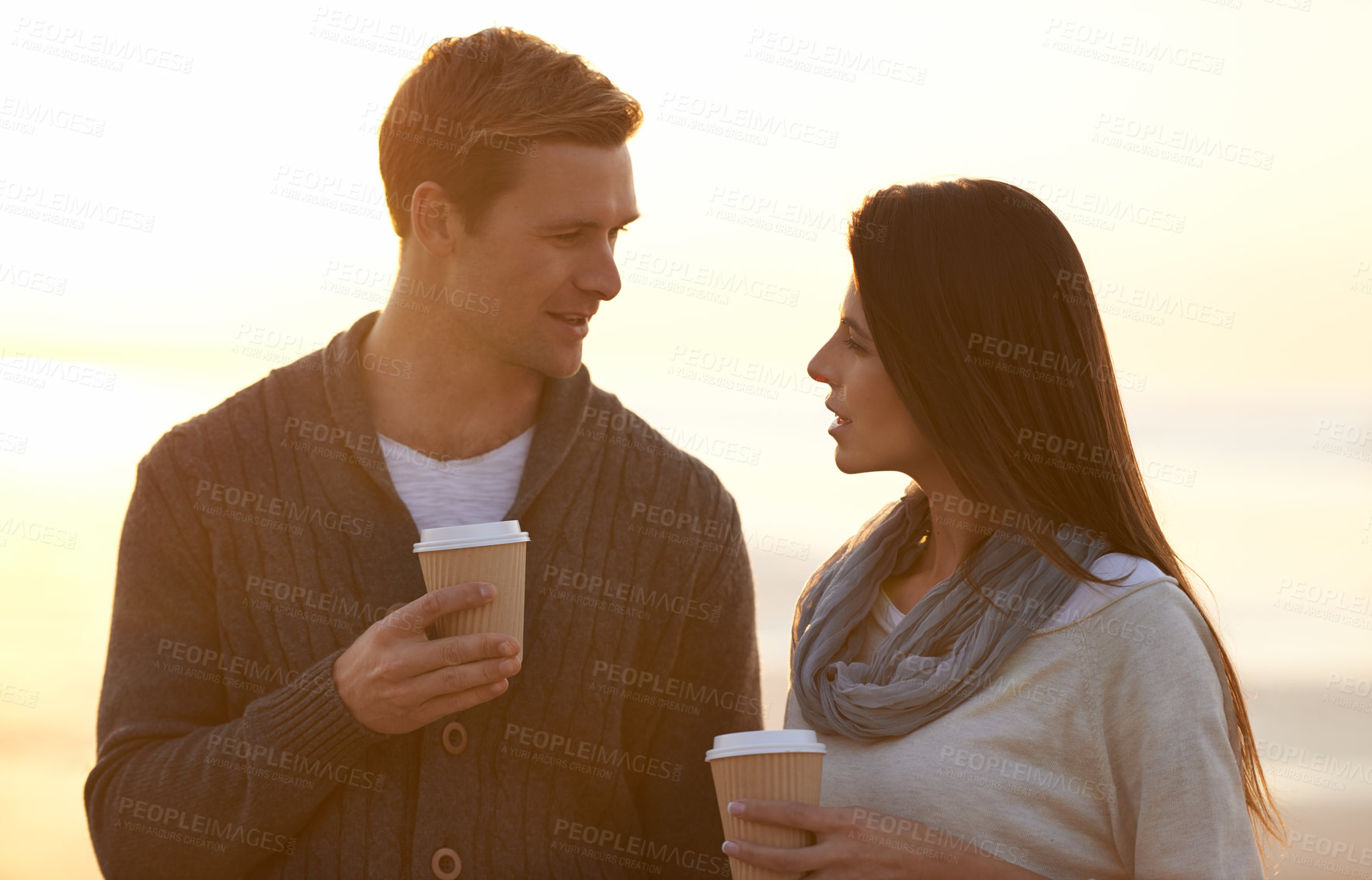 Buy stock photo Couple, coffee and sunset at beach on vacation, walking and conversation in summer by ocean. Man, woman and drink with tea cup with smile, bonding and happy for memory on holiday by sea in Australia