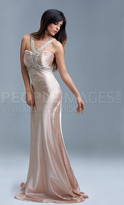 Buy stock photo Shot of a beautiful young woman posing in an elegant dress in studio