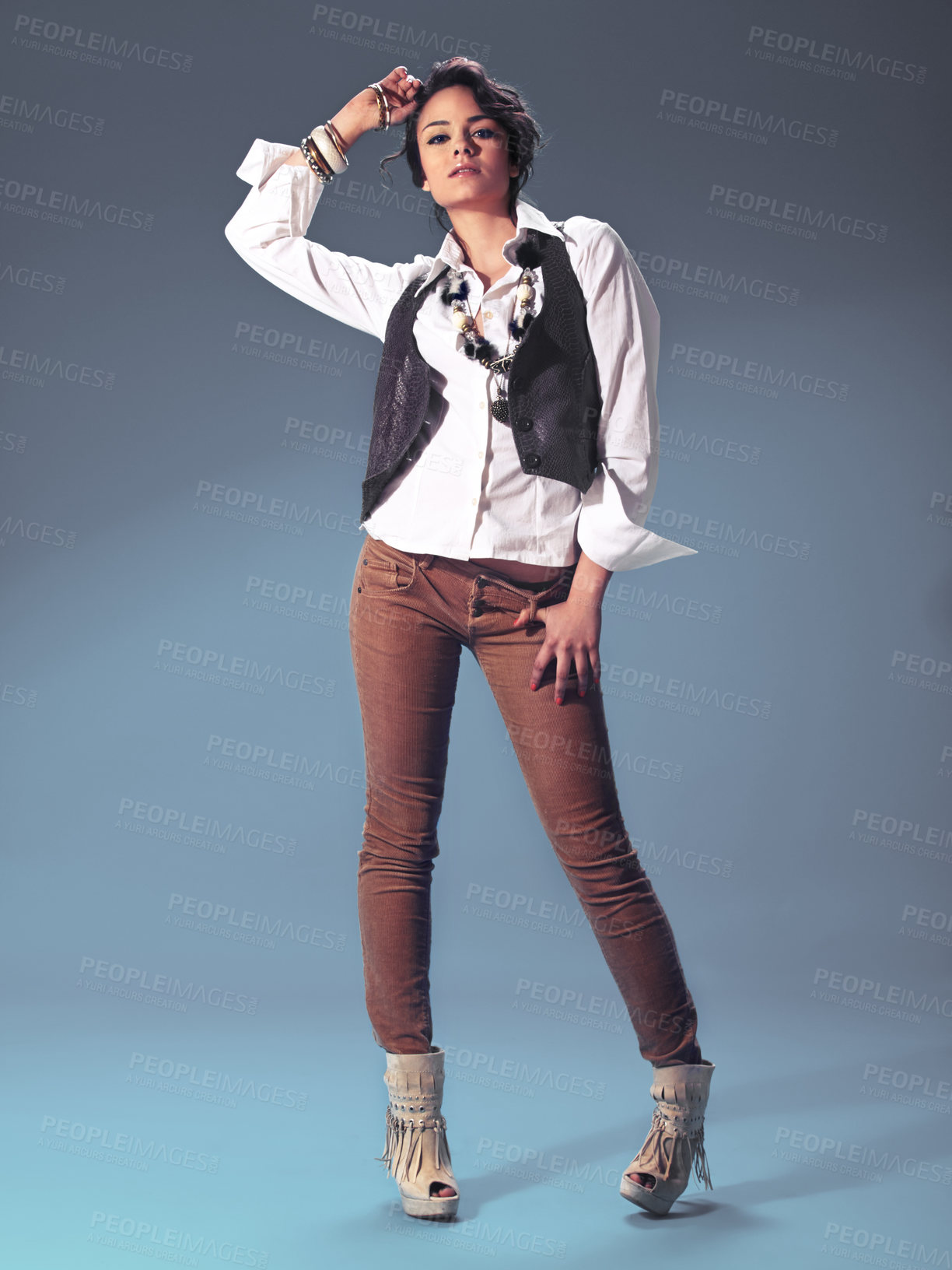 Buy stock photo Studio portrait of a fashionable young woman posing against a blue background