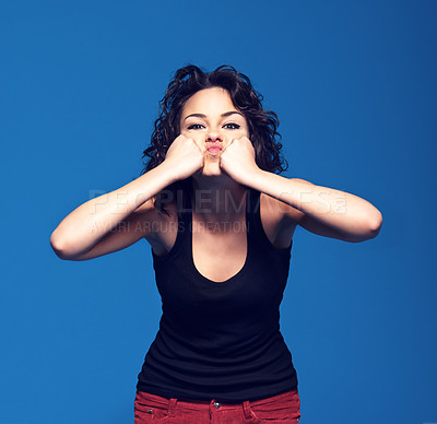 Buy stock photo Studio portrait of a young woman pressing her fists against her face