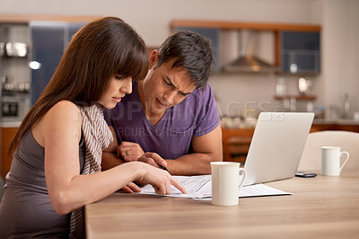 Buy stock photo Shot of a young couple doing their finances at home