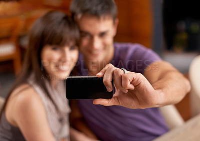 Buy stock photo Love, smile and couple with selfie blur in house for bonding, photography or memory with care. Smartphone, profile picture or people embrace with romance at home for social media, blog or vlog update