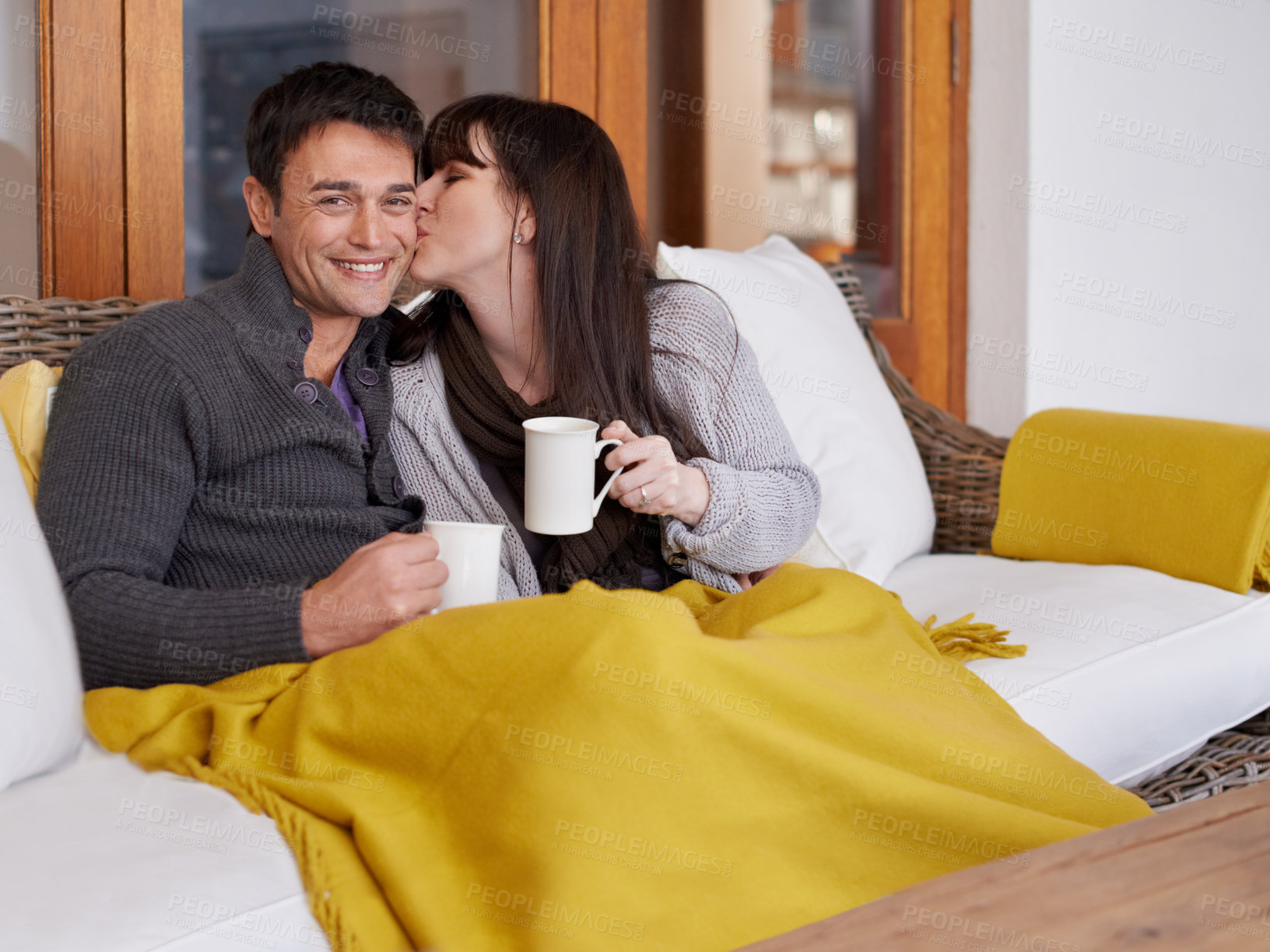 Buy stock photo Shot of a young couple sitting on their sofa and relaxing