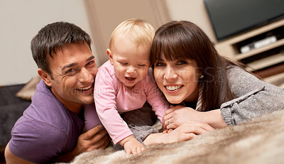 Buy stock photo Shot of a young couple playing with their infant daughter