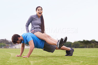 Buy stock photo Man, push up and woman sitting on back with laugh, training or strong with balance in nature. Couple, exercise and workout on grass with smile, muscle or crazy with funny joke for fitness in England