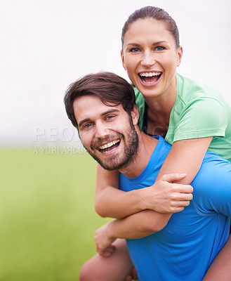 Buy stock photo Shot of a young man playfully carrying his girlfriend on his back while working out
