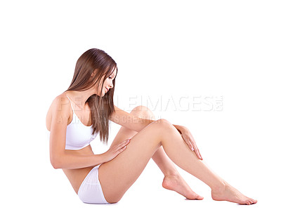 Buy stock photo Full body studio shot of a young woman caressing her bare leg