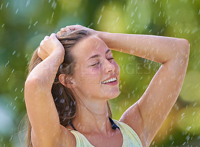 Buy stock photo Cropped shot of a young woman standing happily in the rain