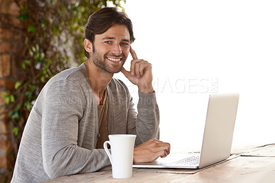 Buy stock photo Portrait of a handsome young man working on his laptop outside