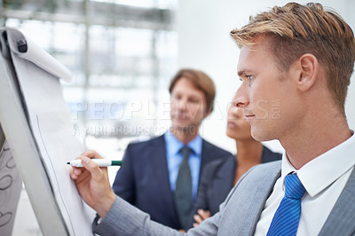 Buy stock photo Businessman, flipchart and writing in office with meeting for project planning, stocks performance and profit management. Financial analyst, employee and person with presentation of data in workplace