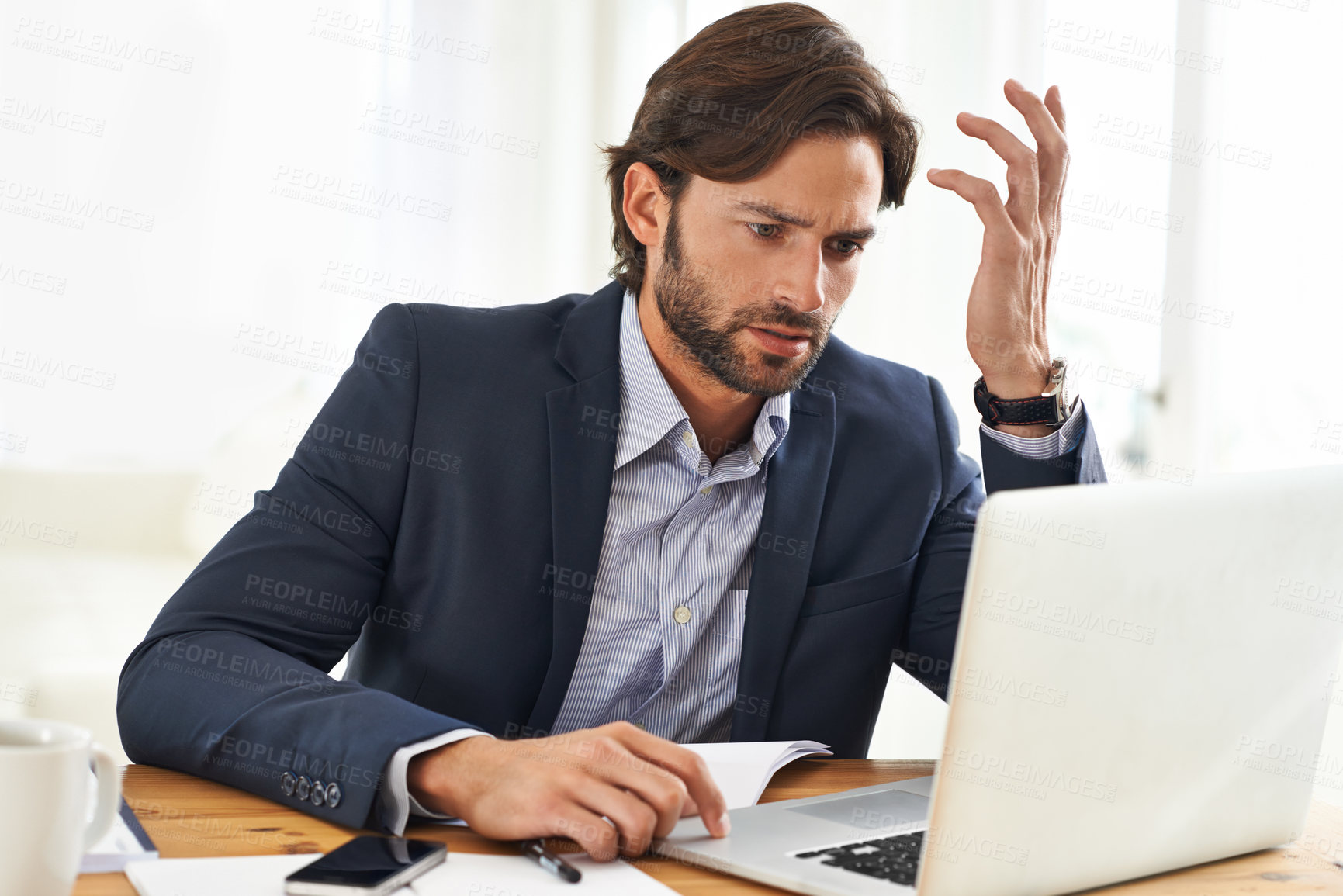 Buy stock photo A handsome businessman working on his laptop