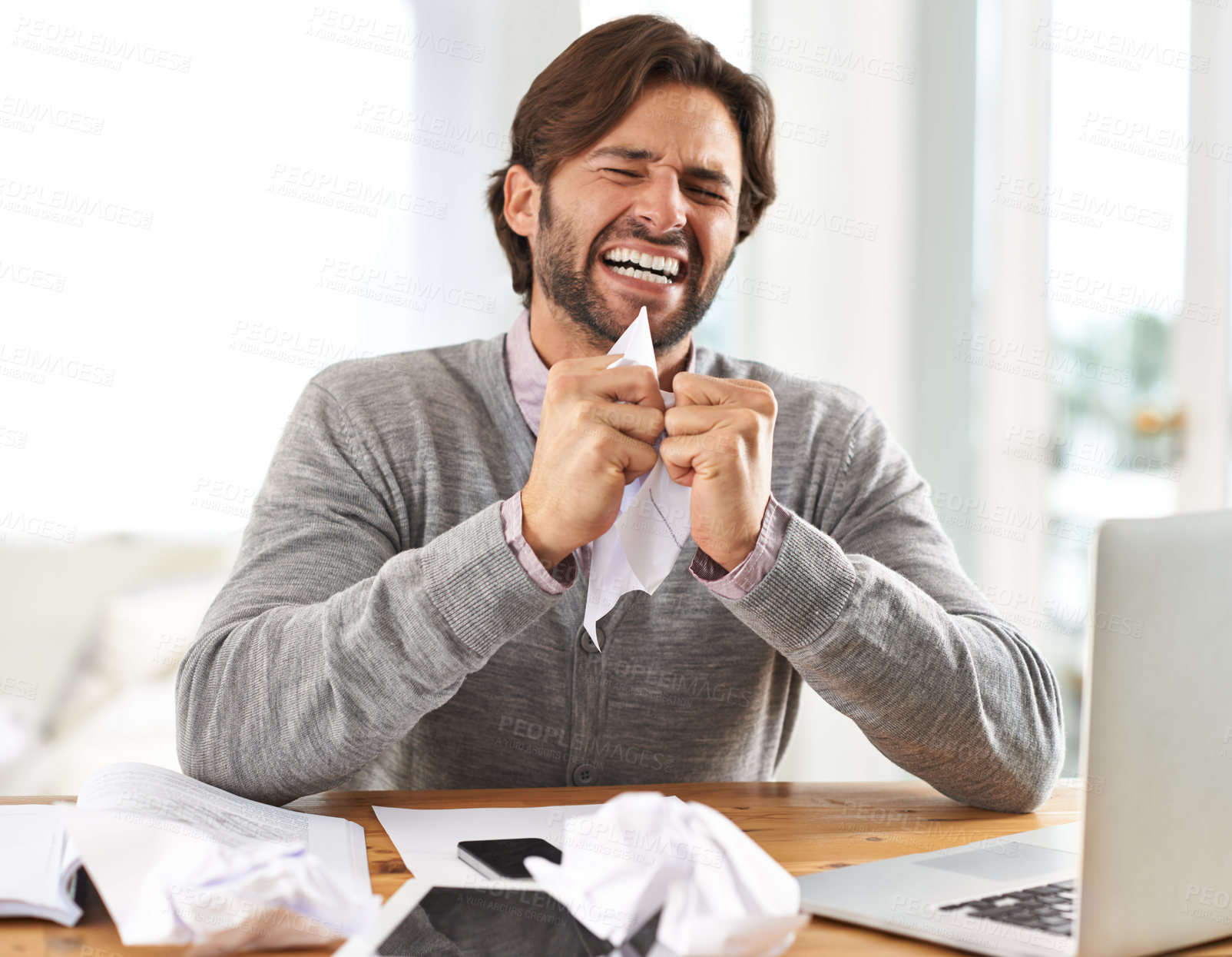 Buy stock photo A handsome businessman crumpling paper in frustration over work stress