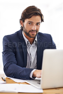 Buy stock photo A portrait of a handsome businessman working on his laptop