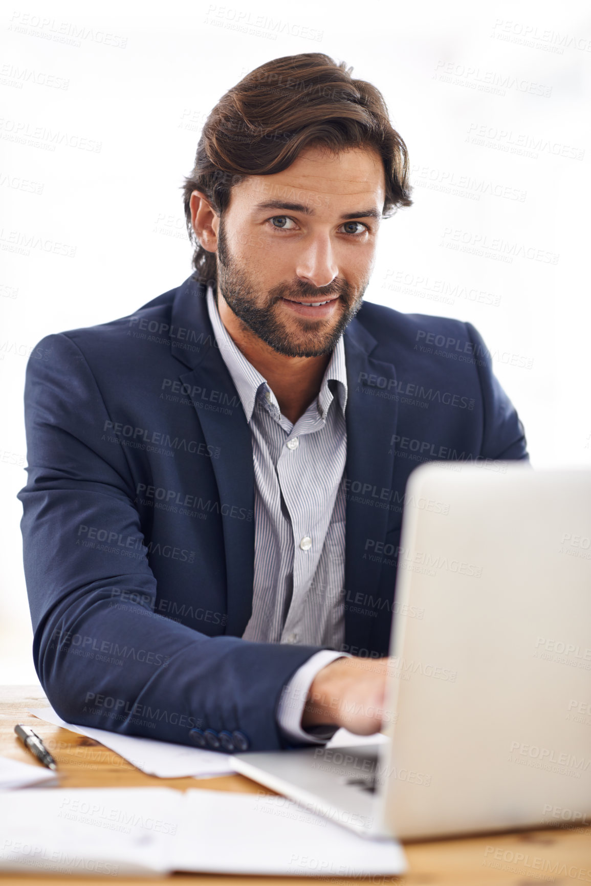 Buy stock photo A portrait of a handsome businessman working on his laptop