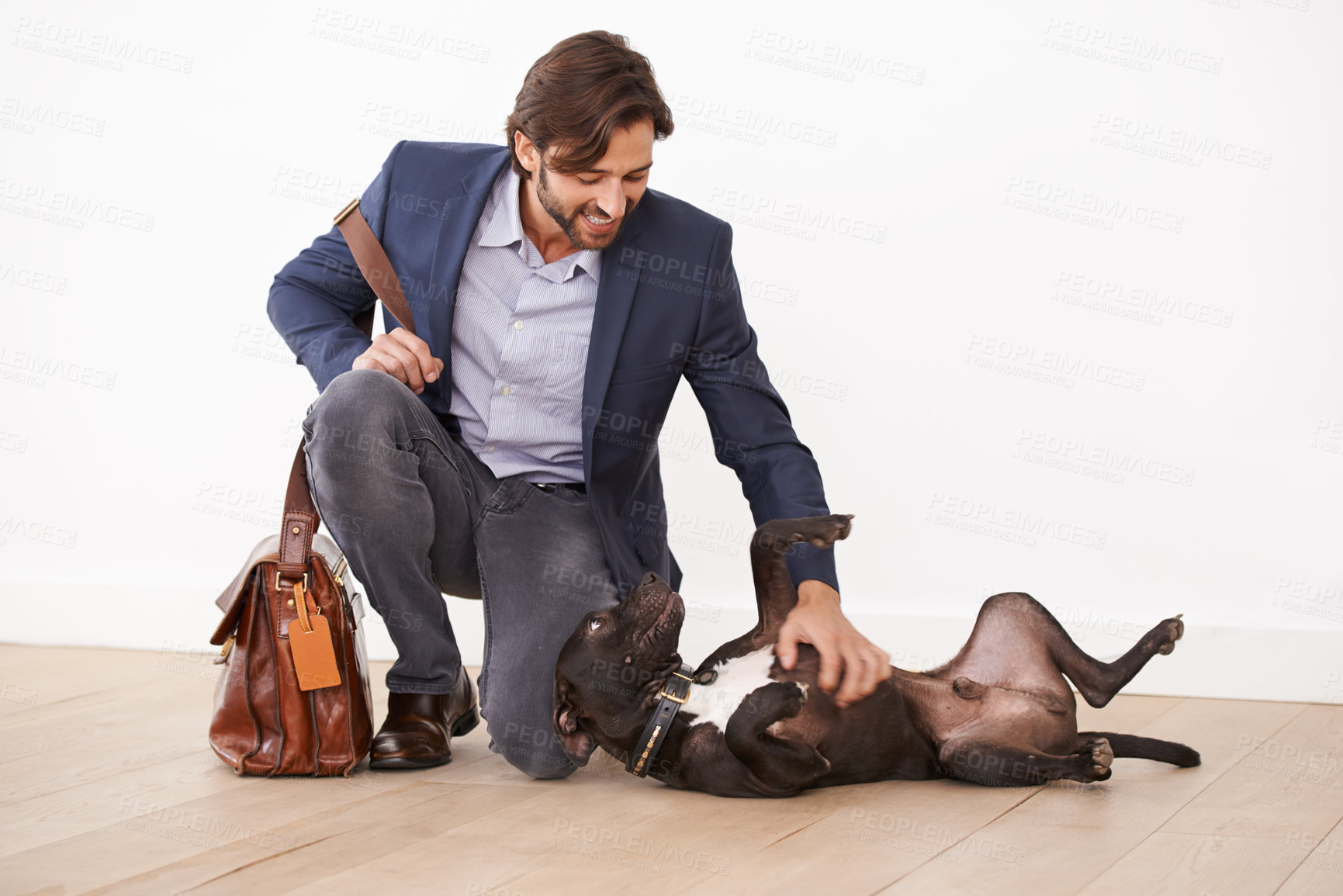 Buy stock photo A handsome businessman playing with his dog