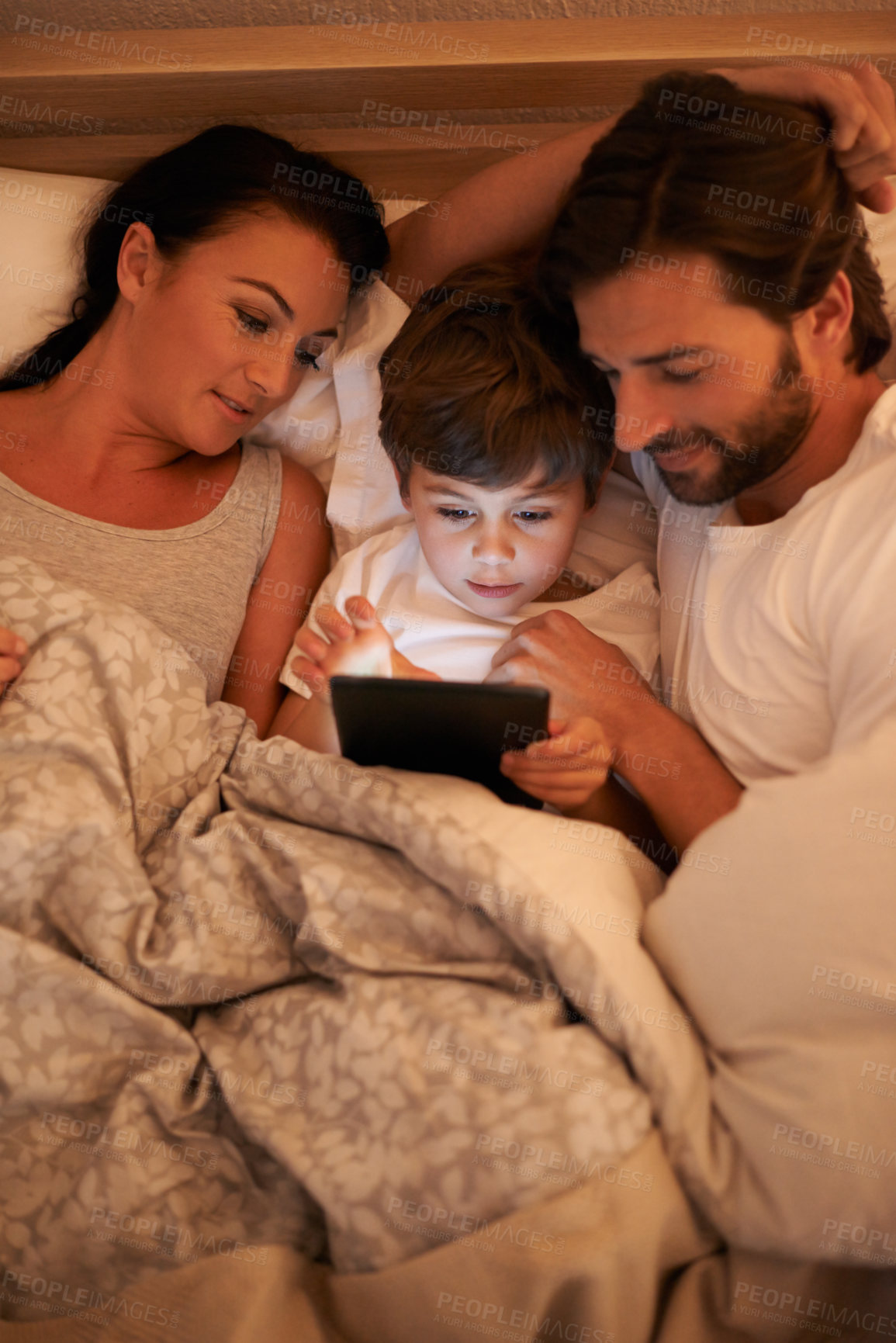 Buy stock photo Parents, watch and boy with tablet in bedroom for movie, digital and educational for learning of child. Family, love and technology with connection to internet for bonding, mom and dad relax with son