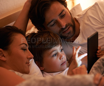 Buy stock photo Parents, boy and tablet in bedroom at night for app, bonding and watch movies together in family house. Dad, mom and child in bed with touchscreen, cartoon or film with streaming subscription in home